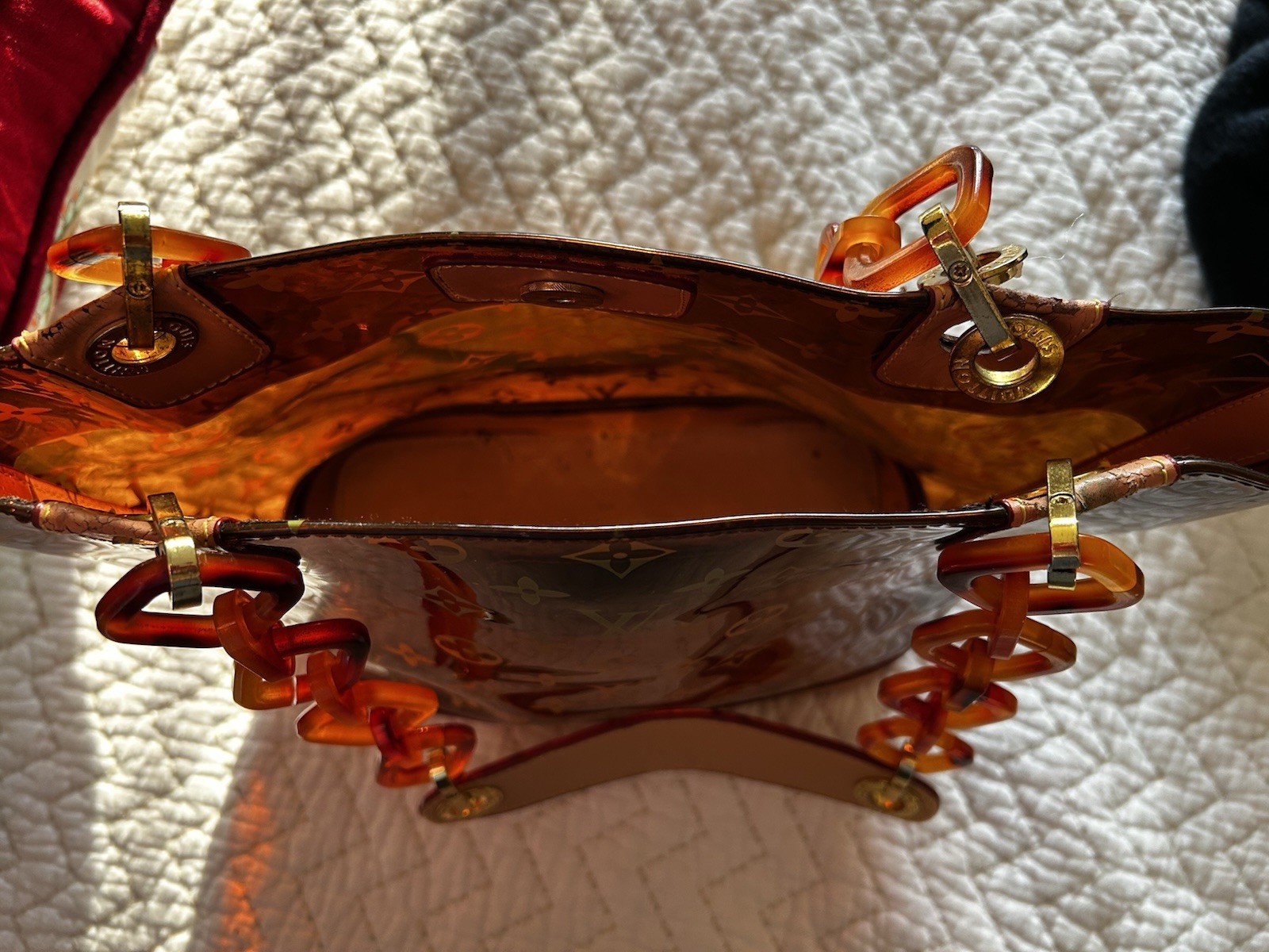 Purse vinyl exterior,amber-colored resin chain straps, and gold-tone hardware