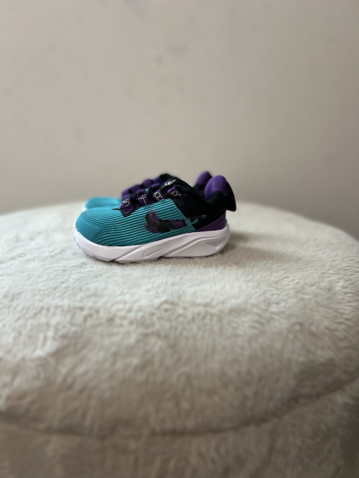 Nike Star Runner 4 sneakers in a teal, purple, and volt colorway Infant Size 4c