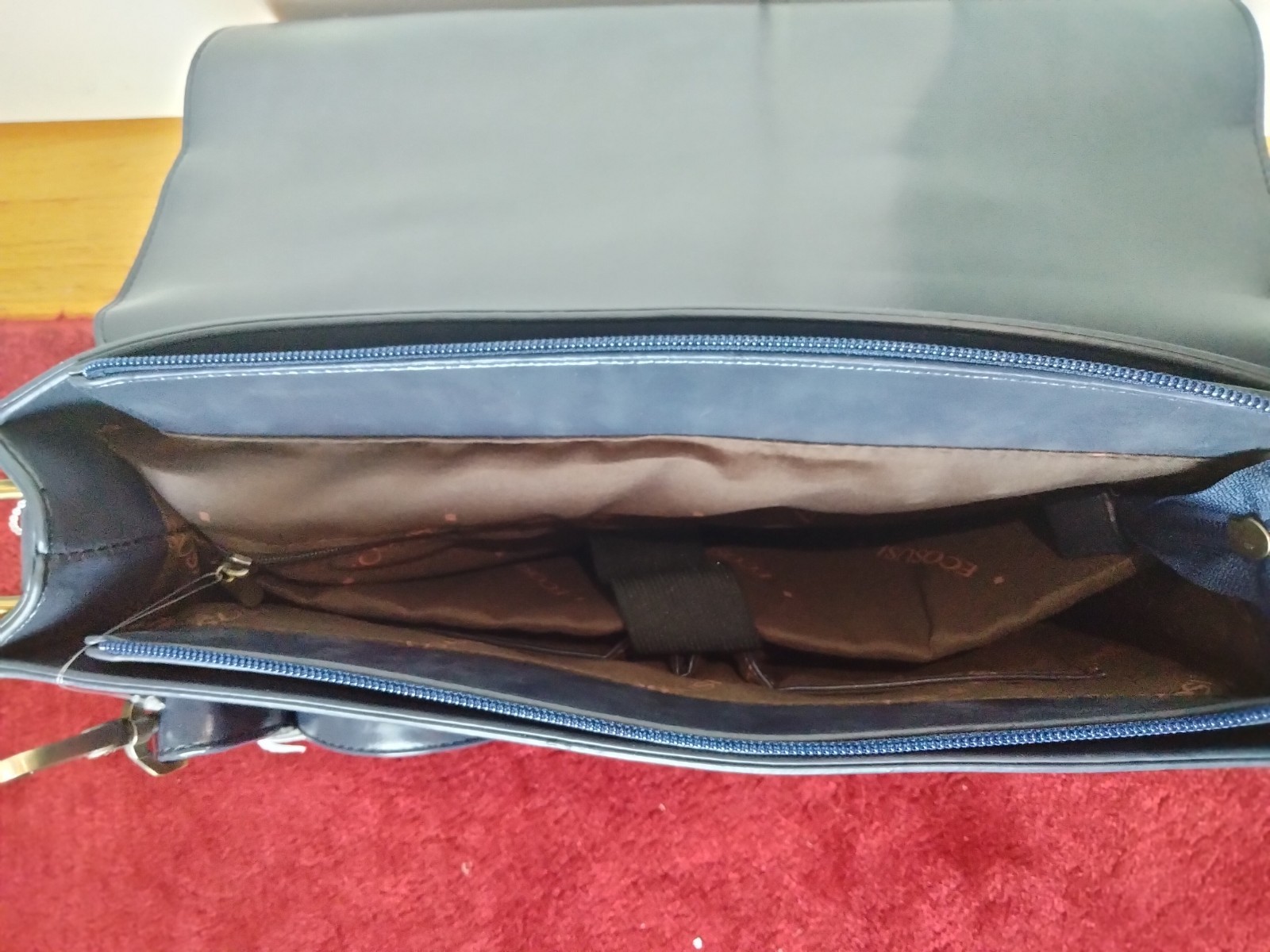 ECOSUSI briefcase features vegan leather construction and a protective handle…