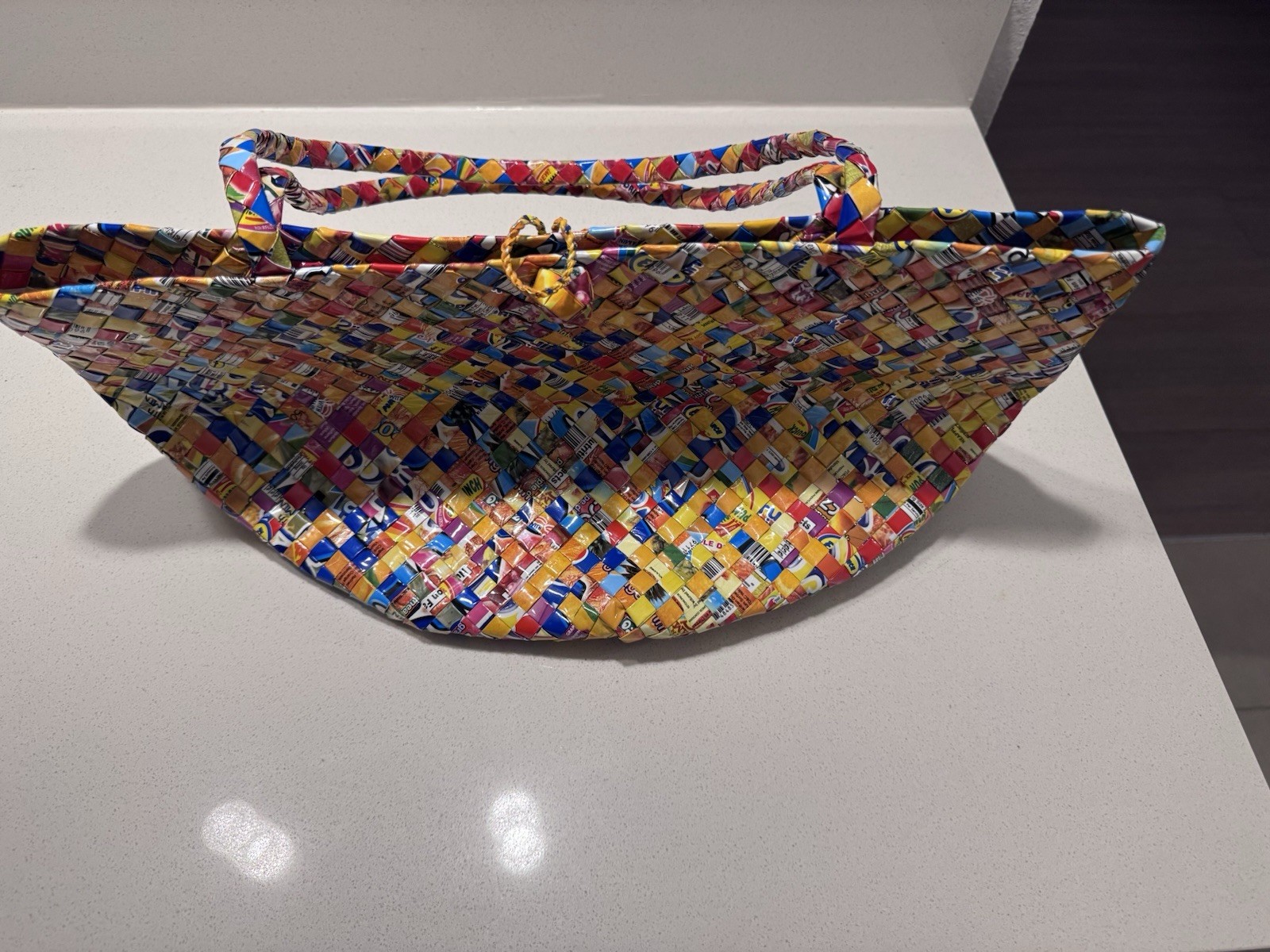 Handwoven luxury tote made from recycled plastic packaging.