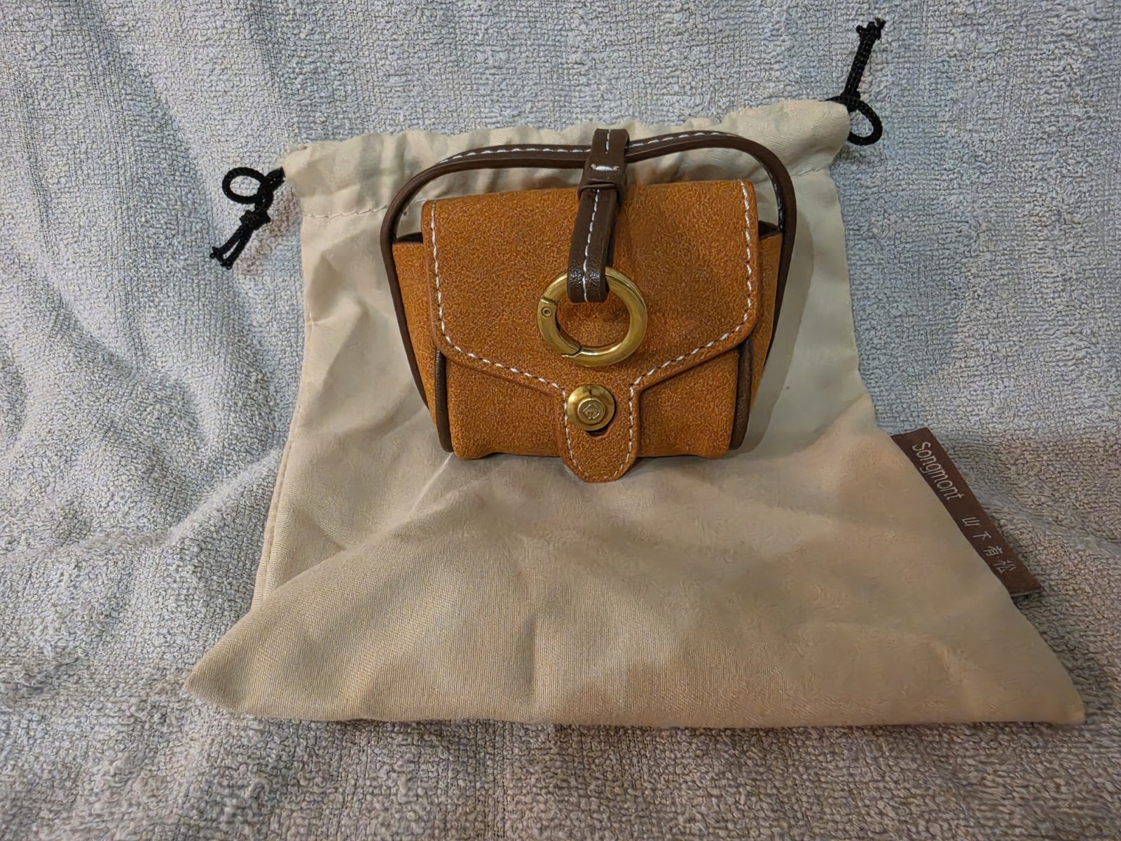 Songmont Brown earbud case with dust Bag.