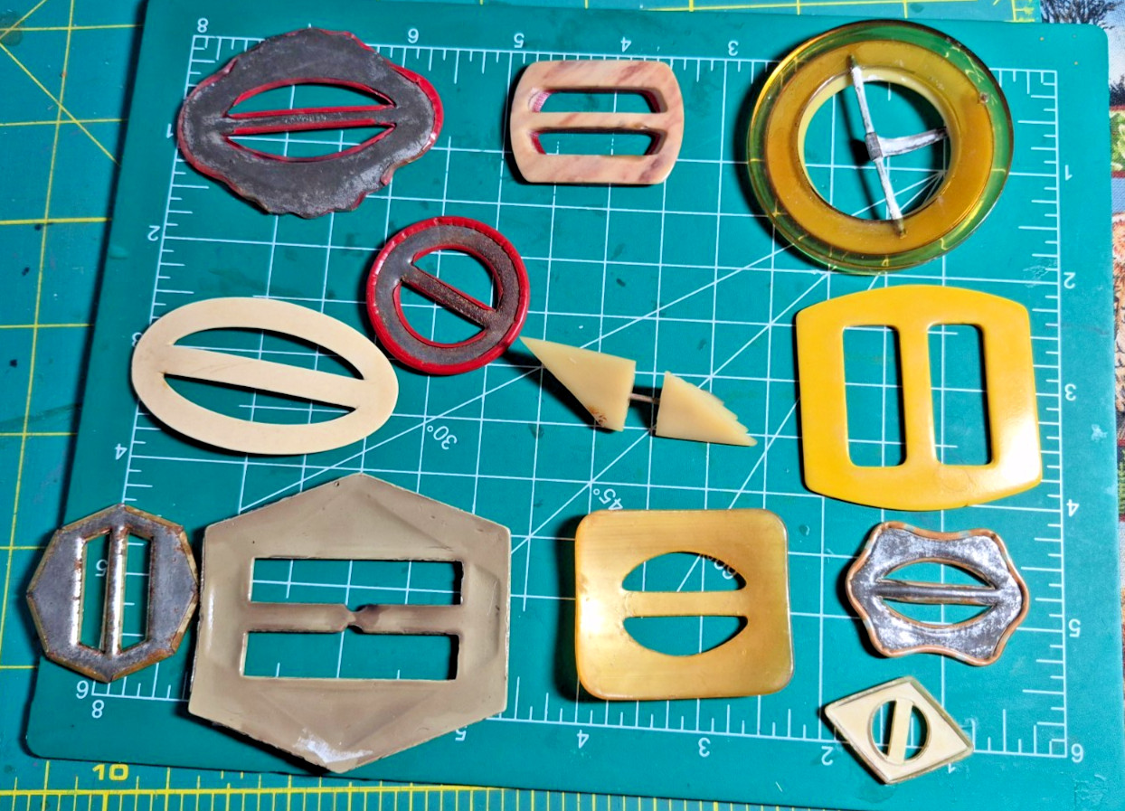 12 Vintage antique celluloid buckles or slides reds yellow art deco shapes