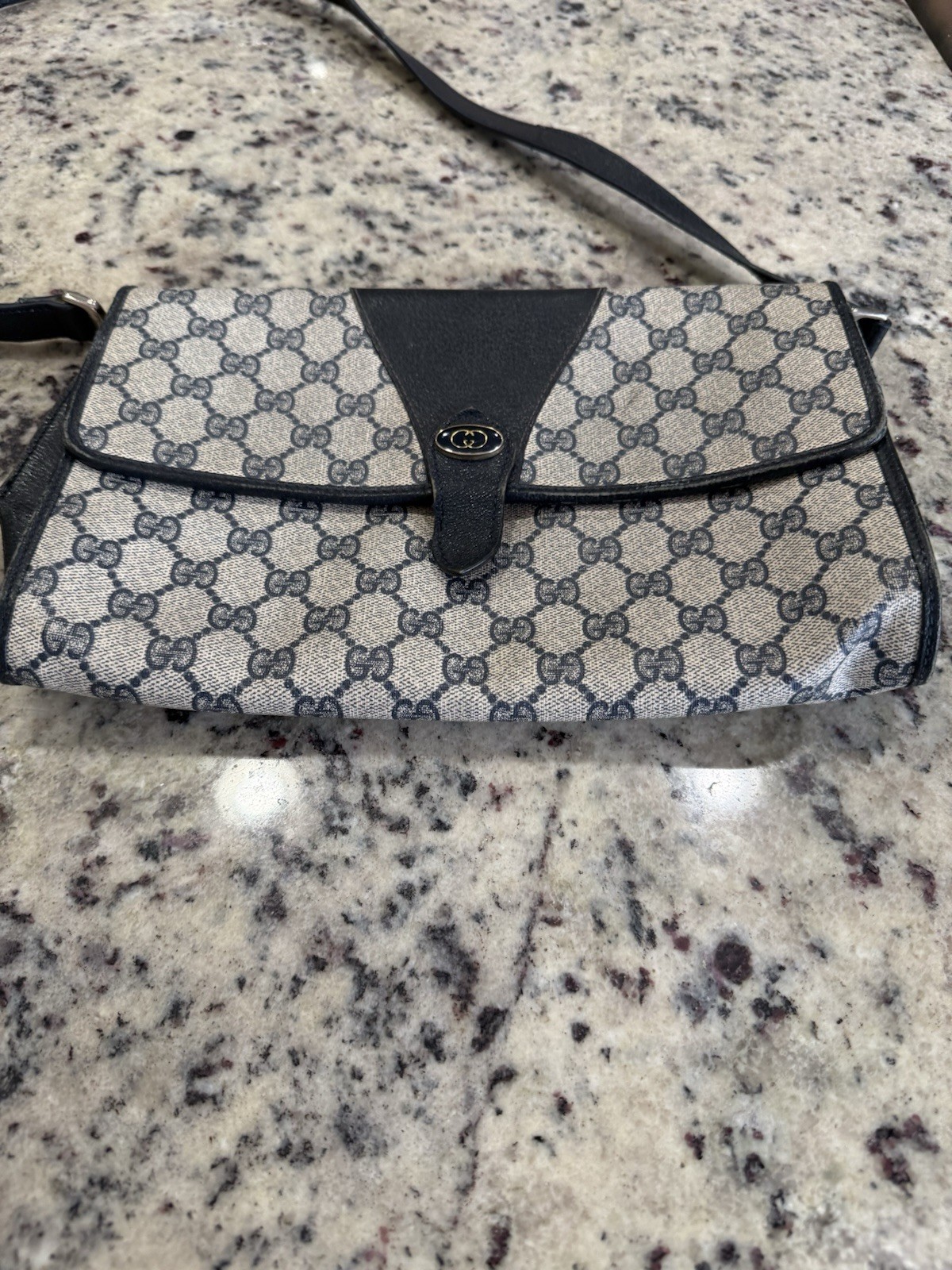 Vintage Gucci crossbody bag with the signature GG monogram pattern.