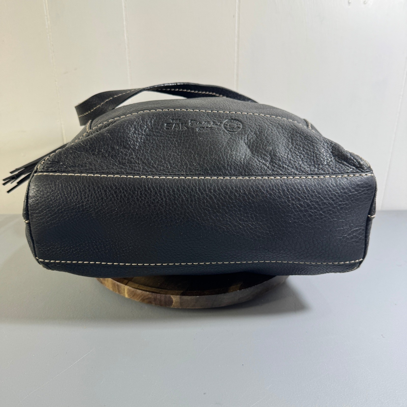 The Sak Black Leather Tote Bag With White Stitching And Tassel Accent Timeless