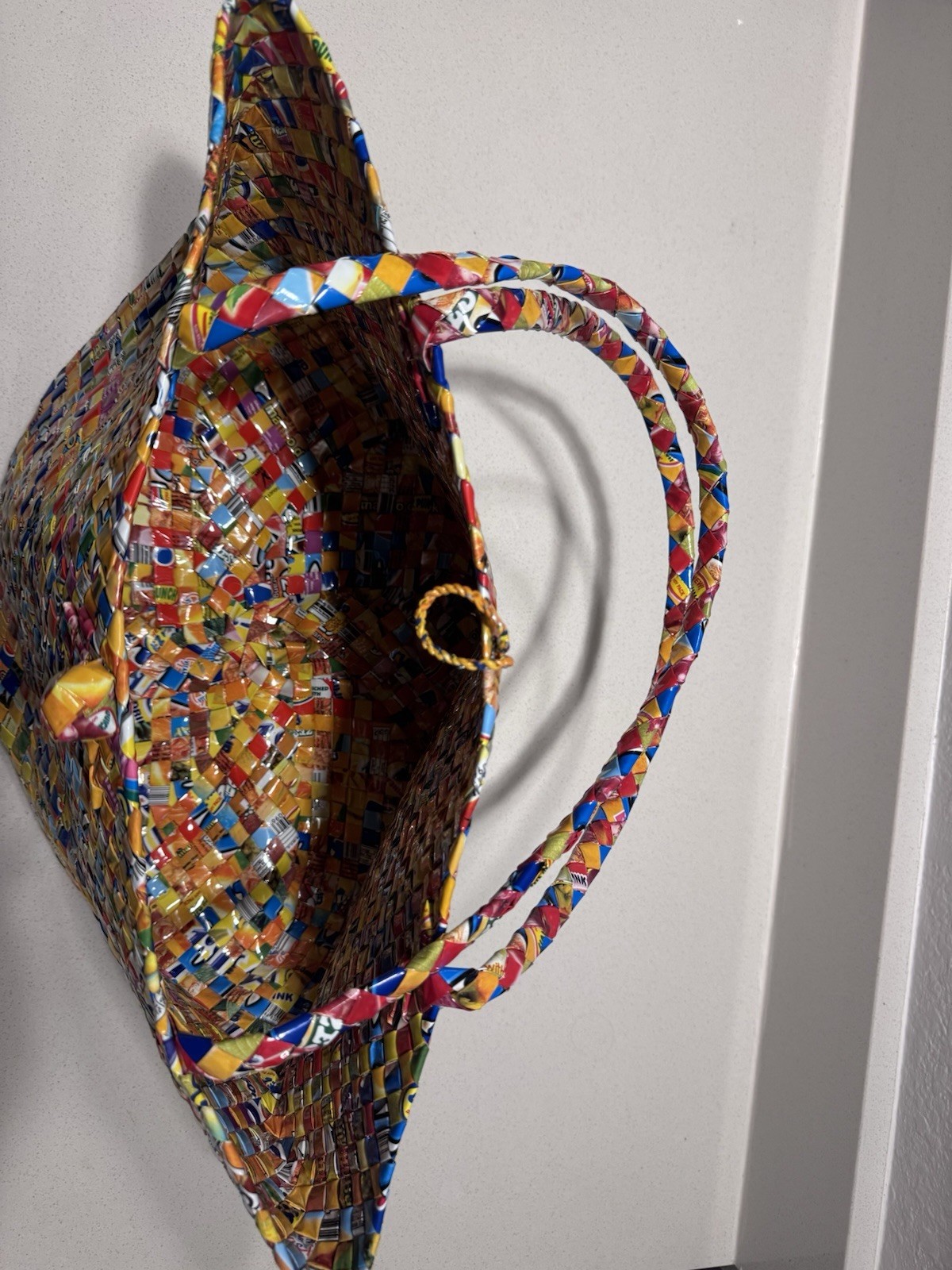 Handwoven luxury tote made from recycled plastic packaging.