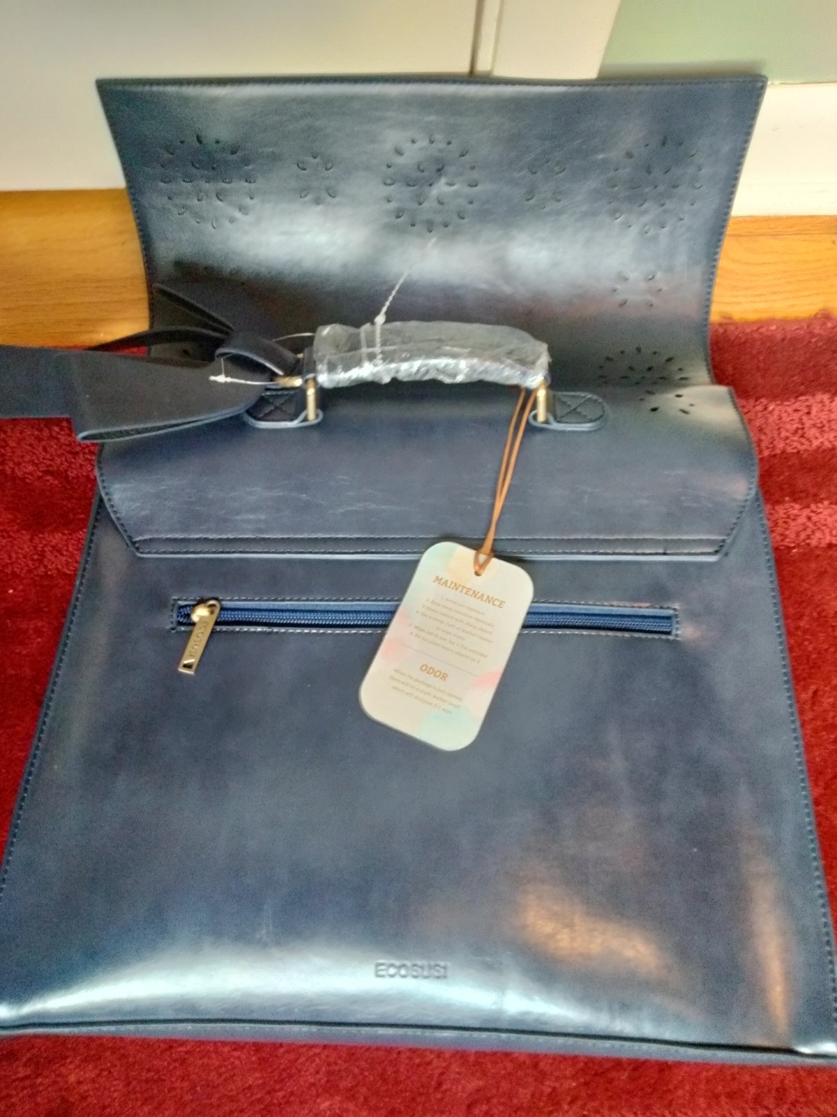 ECOSUSI briefcase features vegan leather construction and a protective handle…