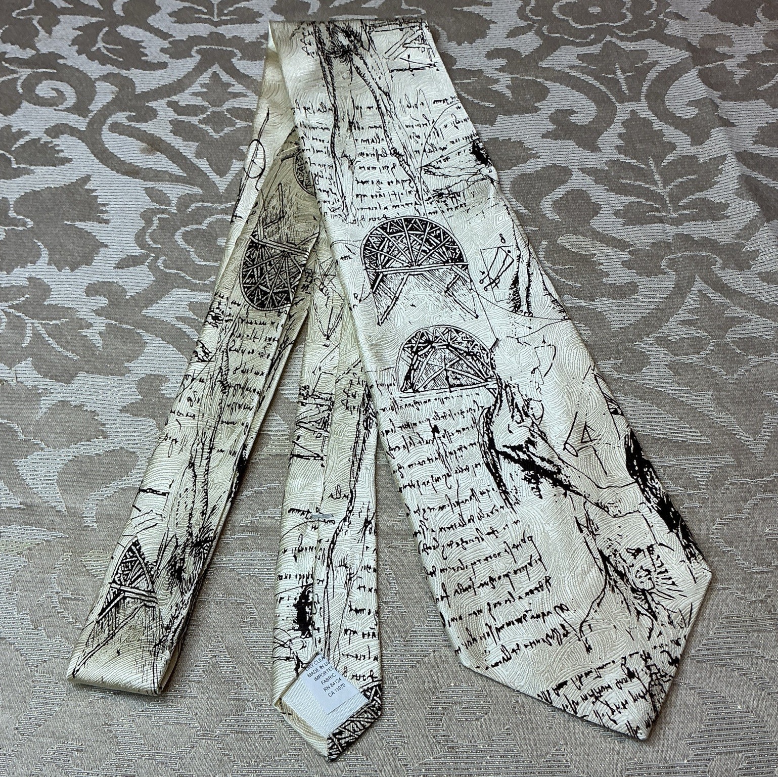 RM Style Men’s Woven Silk Graphic Print Tie Ivory/Black Da Vinci Logo 1-Piece
