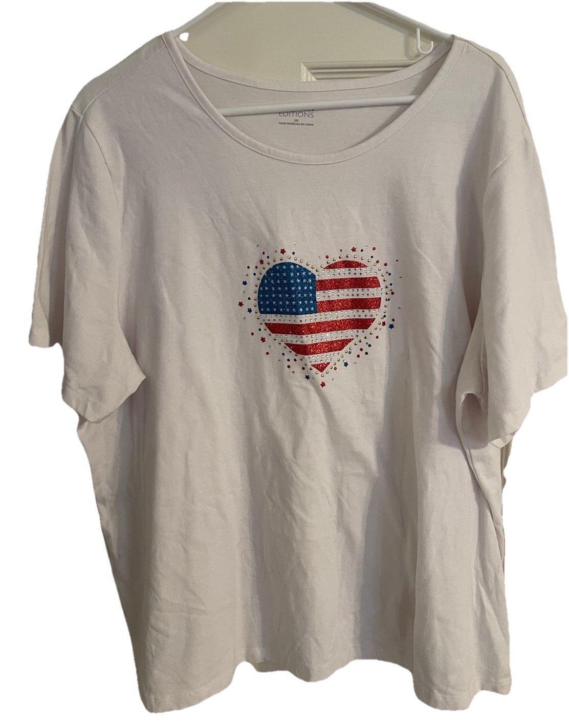 White shirt with heart graphic filled with a red, white, and blue American flag