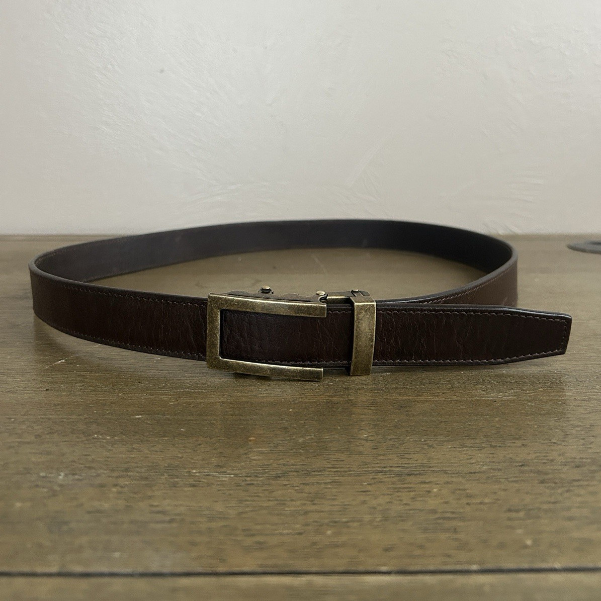 Anson Men’s Brown Leather Adjustable Belt. Metal Buckle. Logo Accent.