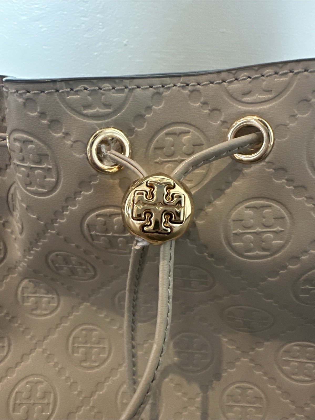 Tory Burch T Monogram debossed leather bucket bag in a “Fresh Clay”