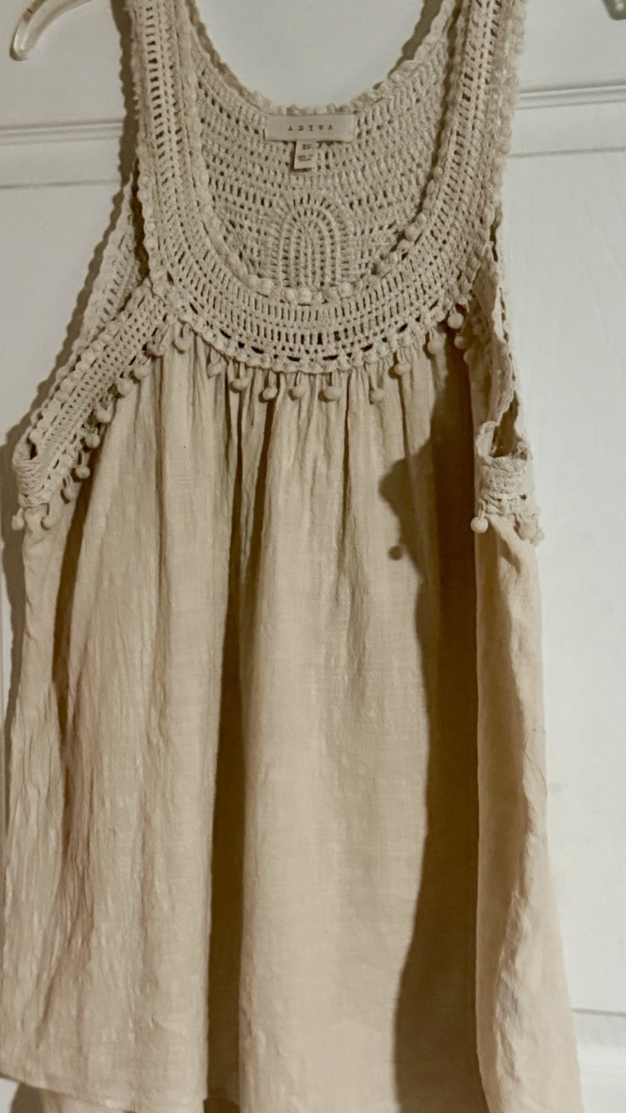 Adiva cream sleeveless top featuring a distinctive crochet yoke and pom-pom trim