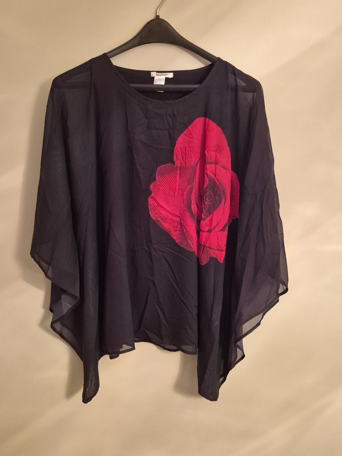 Sheer black poncho style top with tank top lining. Red floral design.
