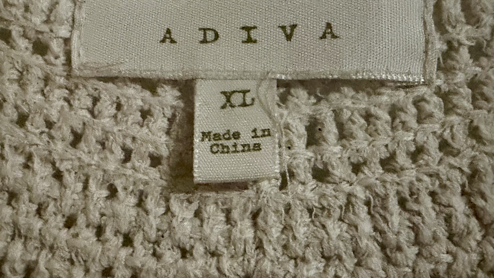 Adiva cream sleeveless top featuring a distinctive crochet yoke and pom-pom trim