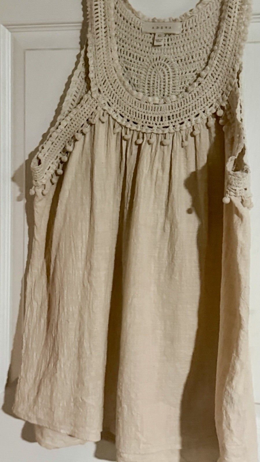 Adiva cream sleeveless top featuring a distinctive crochet yoke and pom-pom trim