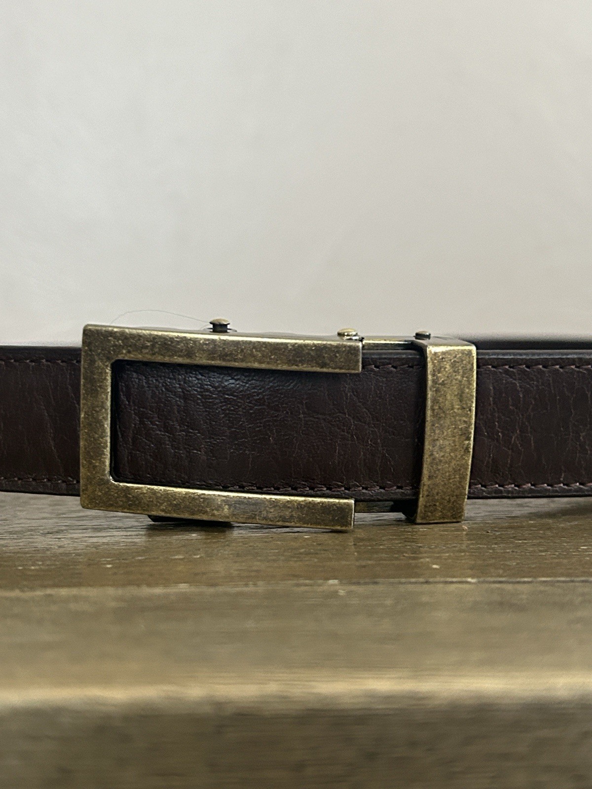 Anson Men’s Brown Leather Adjustable Belt. Metal Buckle. Logo Accent.