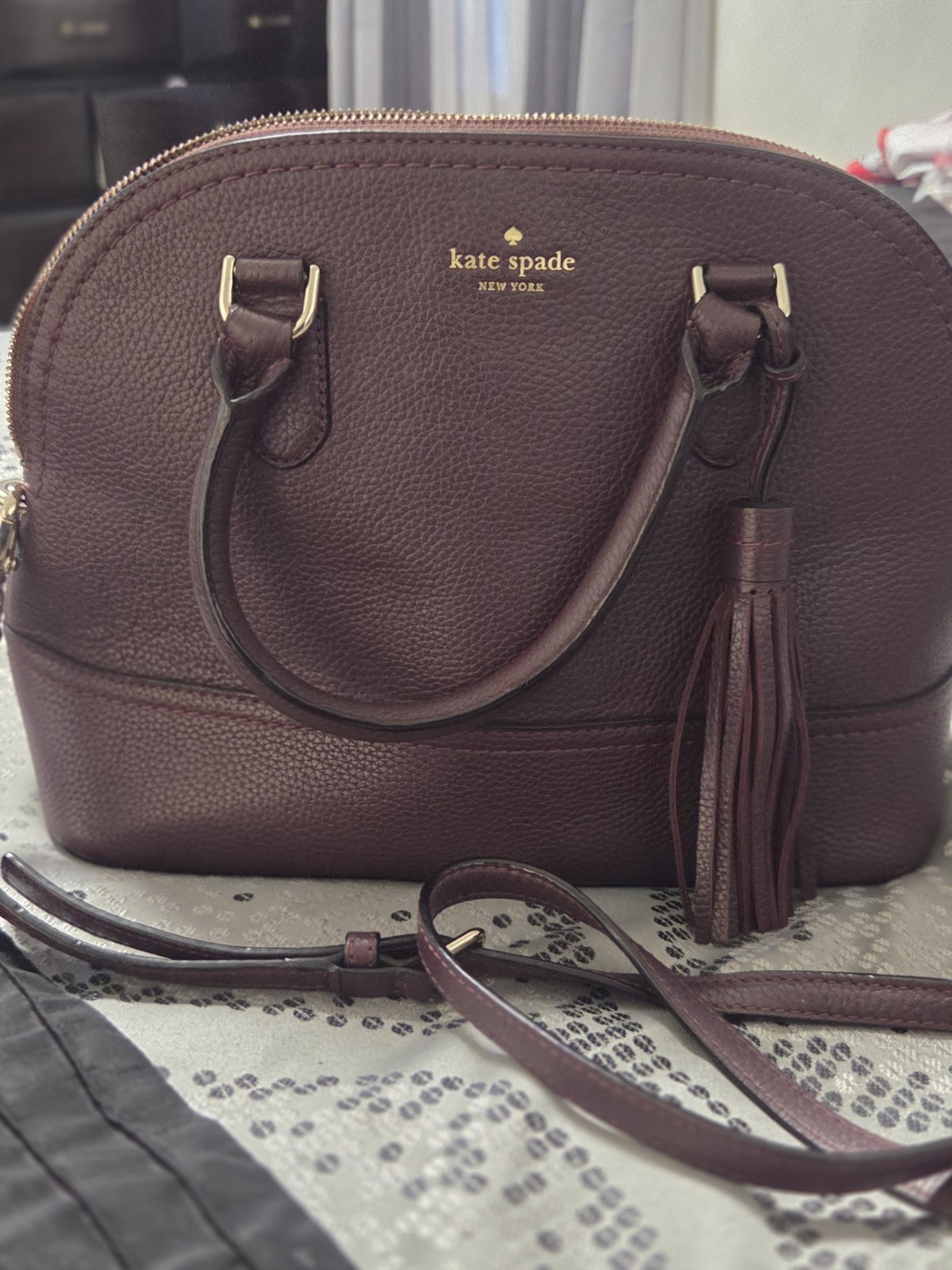 kate spade new york Women’s Burgundy Pebbled Logo Dome Satchel Gold Tassel Strap