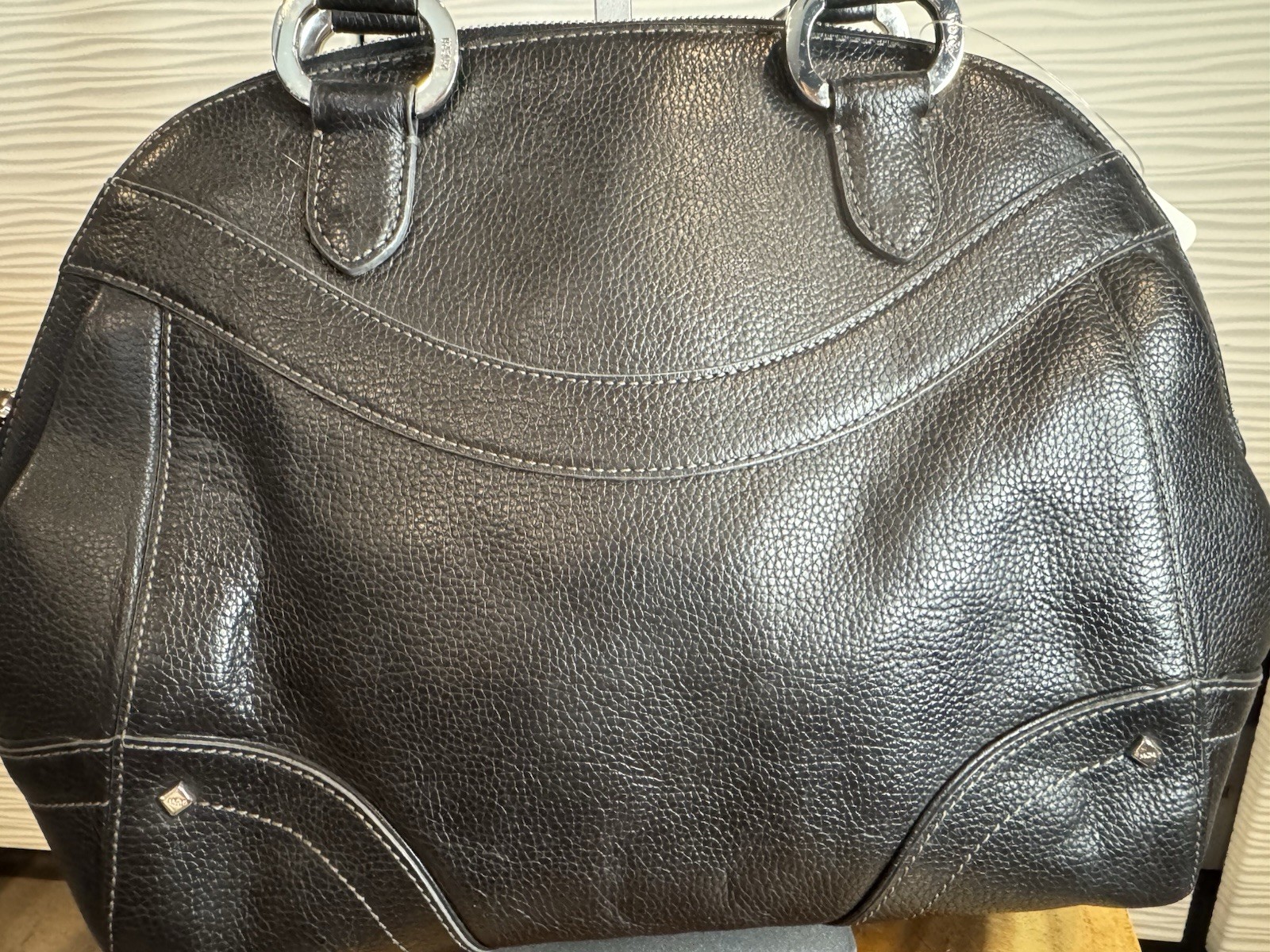 Black MCM Alda satchel with studded logo accents and structured handles.