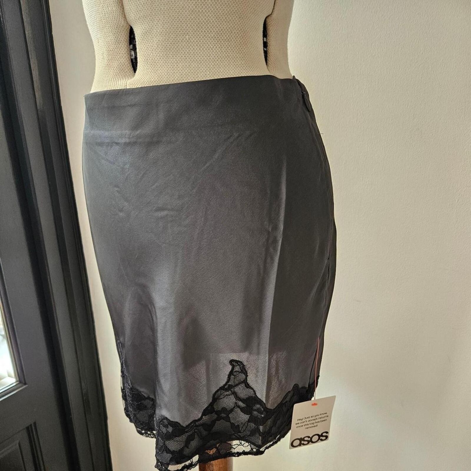 ASOS grey/ gunmetal silver satin mini skirt with black lace trim at the hem.