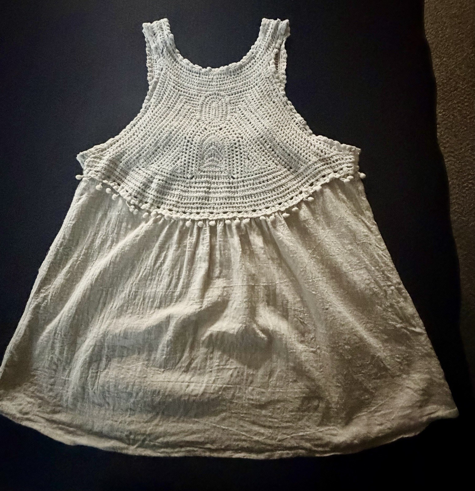 Adiva cream sleeveless top featuring a distinctive crochet yoke and pom-pom trim