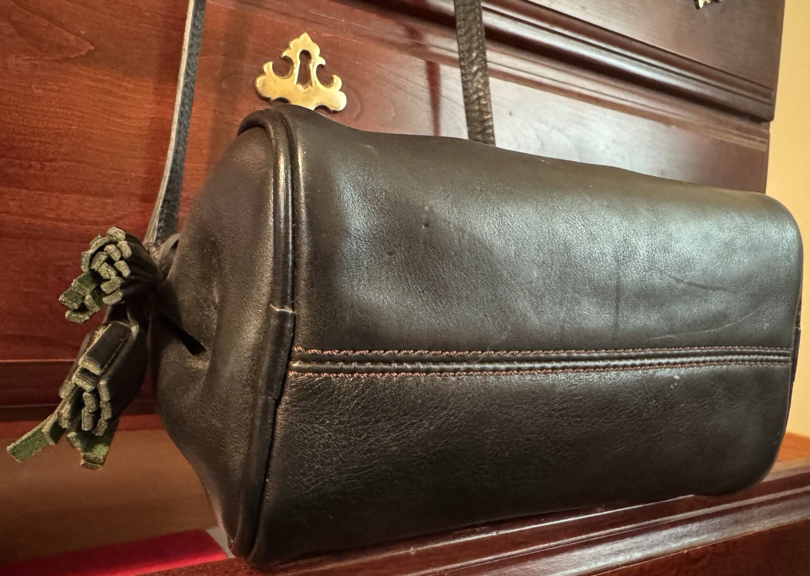Dooney & Bourke Florentine Black Crossbody Tassel Red Lining adjustable Strap.