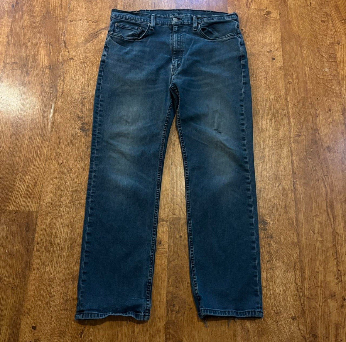 faded Levi’s 514 blue jeans size 38×30 with distressed areas, straight-leg