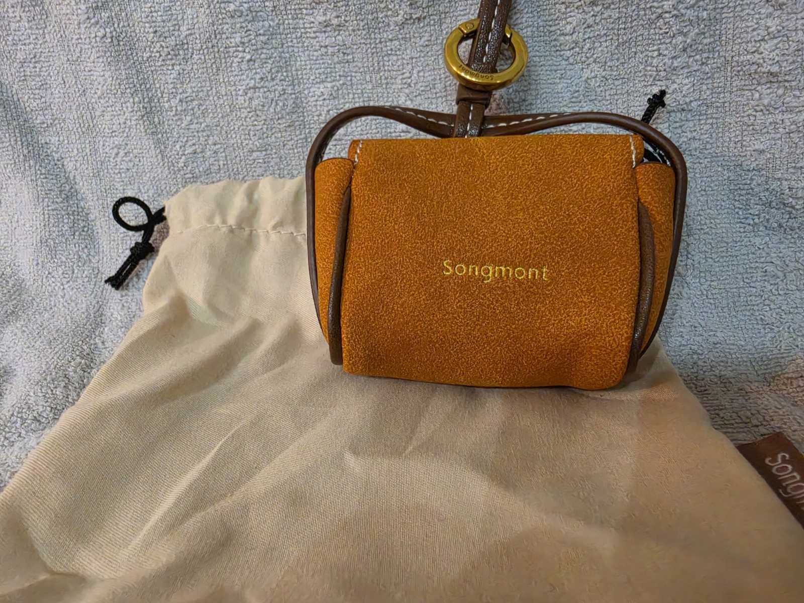 Songmont Brown earbud case with dust Bag.
