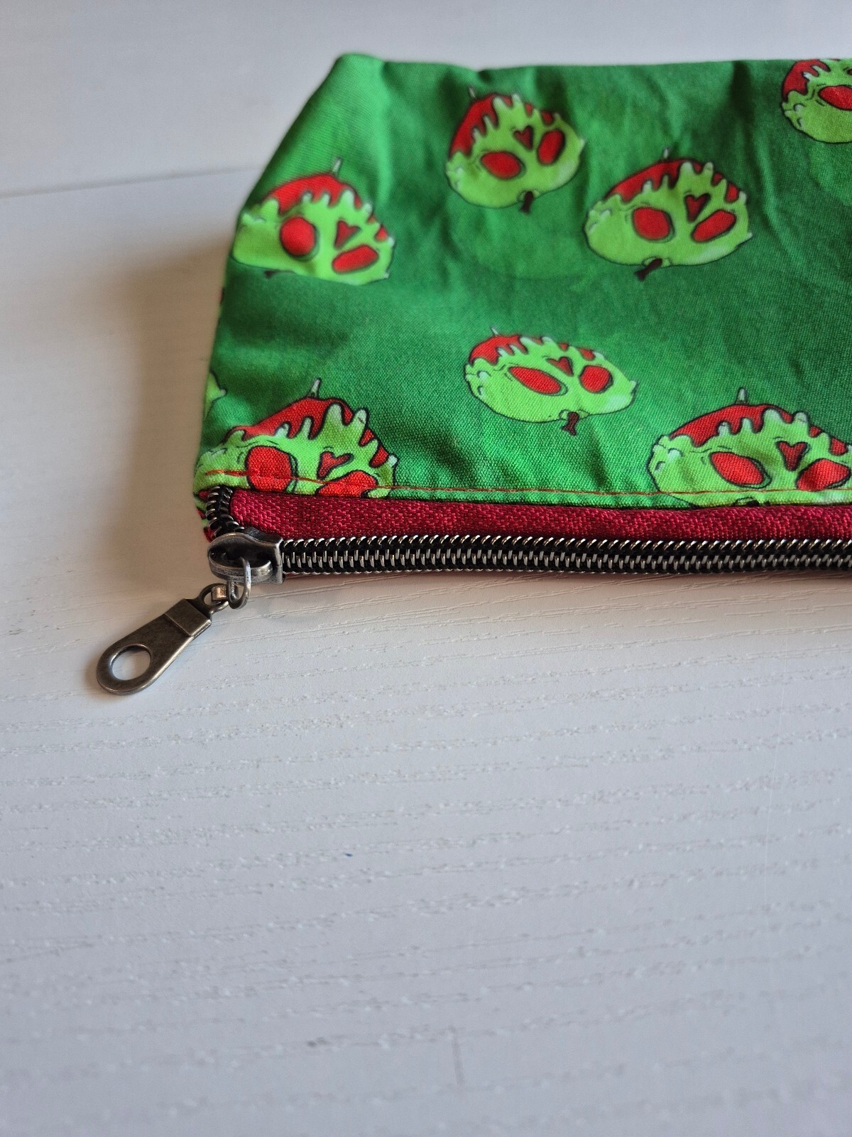 poison red apple on green cotton fabric Cosmetic Pouch, w/ red canvas lining