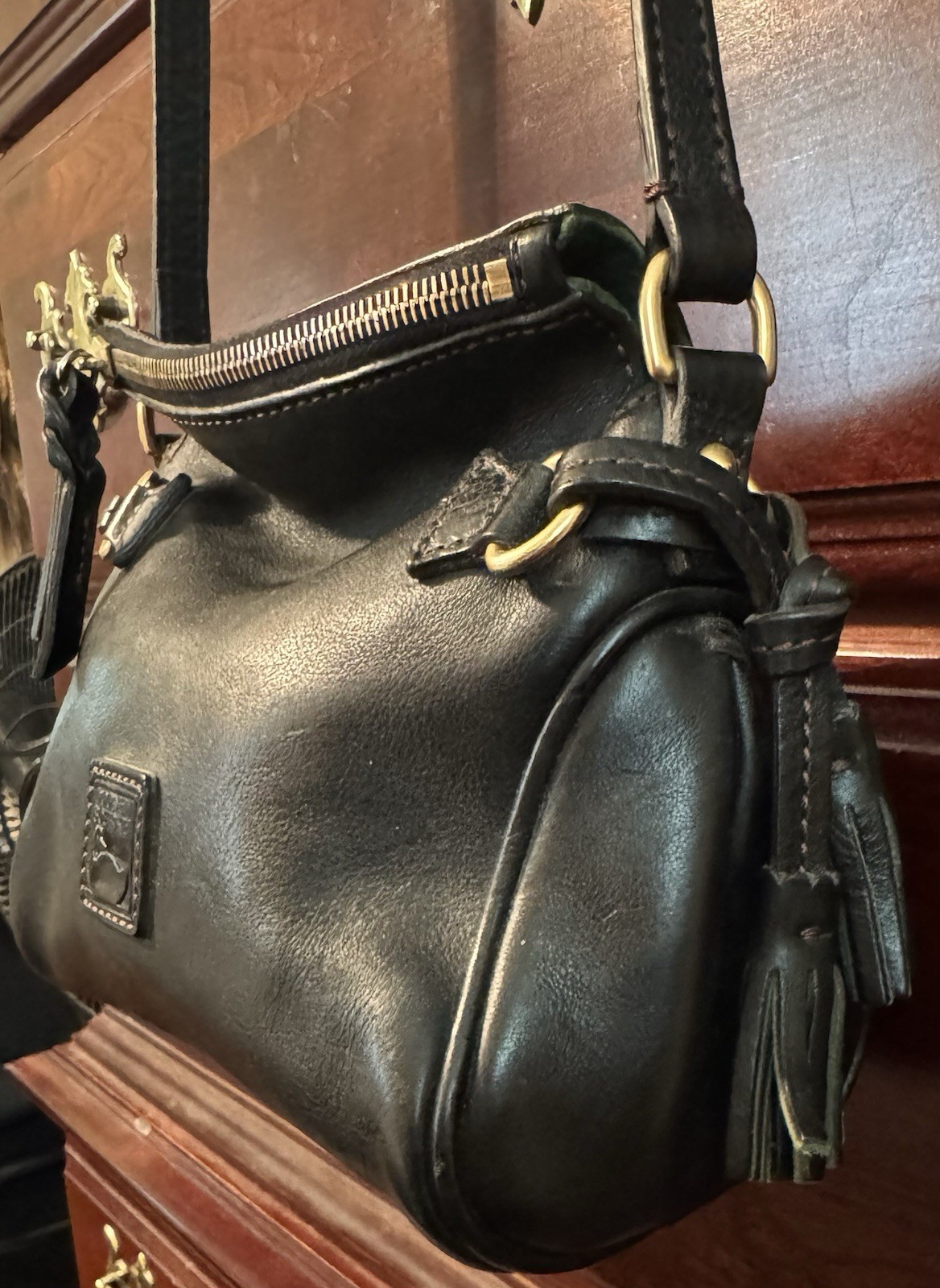 Dooney & Bourke Florentine Black Crossbody Tassel Red Lining adjustable Strap.