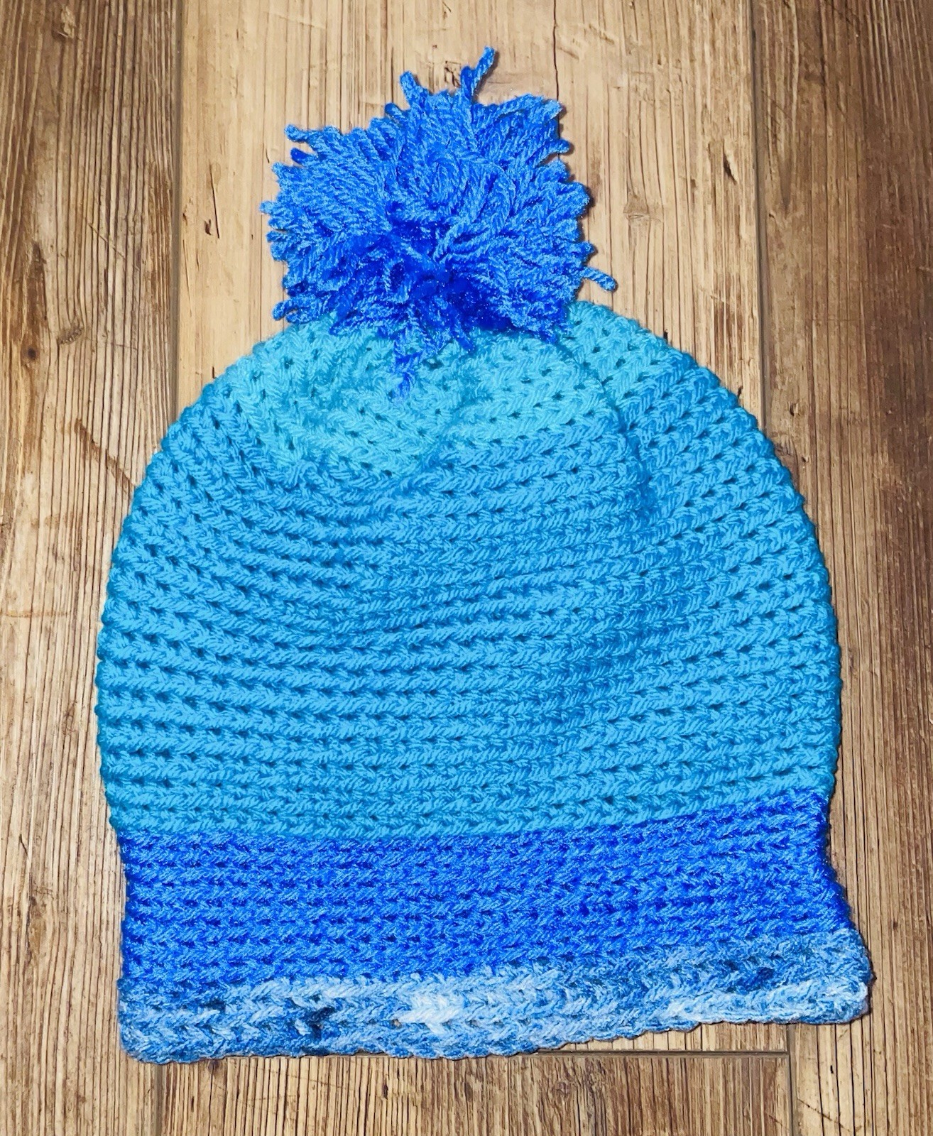 Homemade Different Colors Of Blue Crocheted Hat With A Pom-Pom On Top