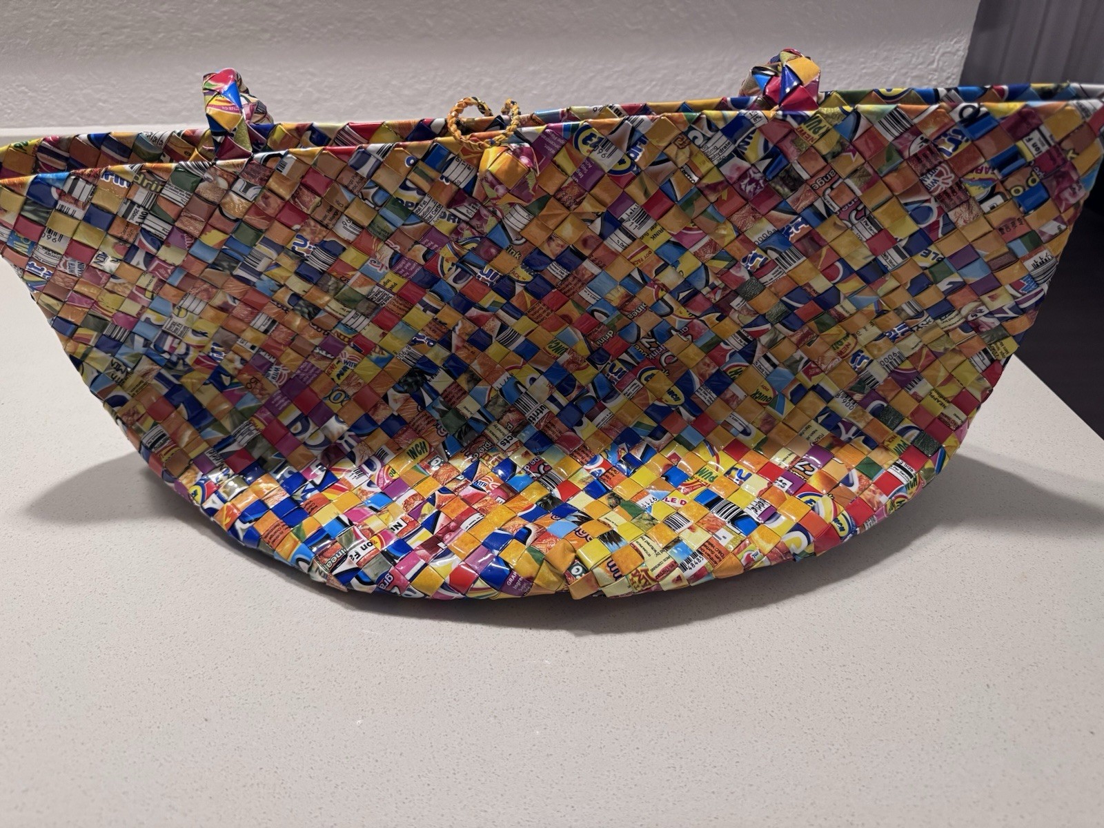 Handwoven luxury tote made from recycled plastic packaging.