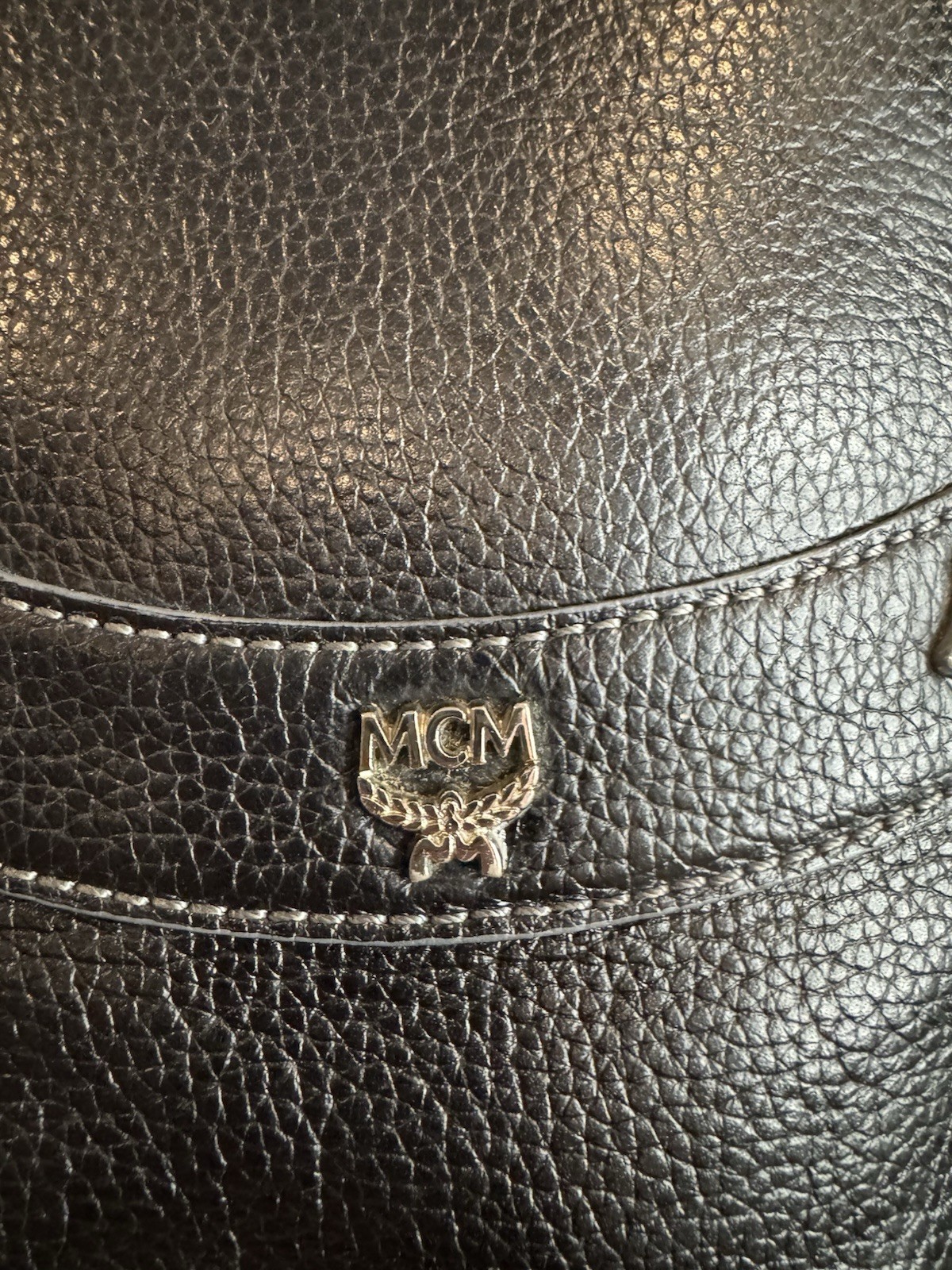 Black MCM Alda satchel with studded logo accents and structured handles.