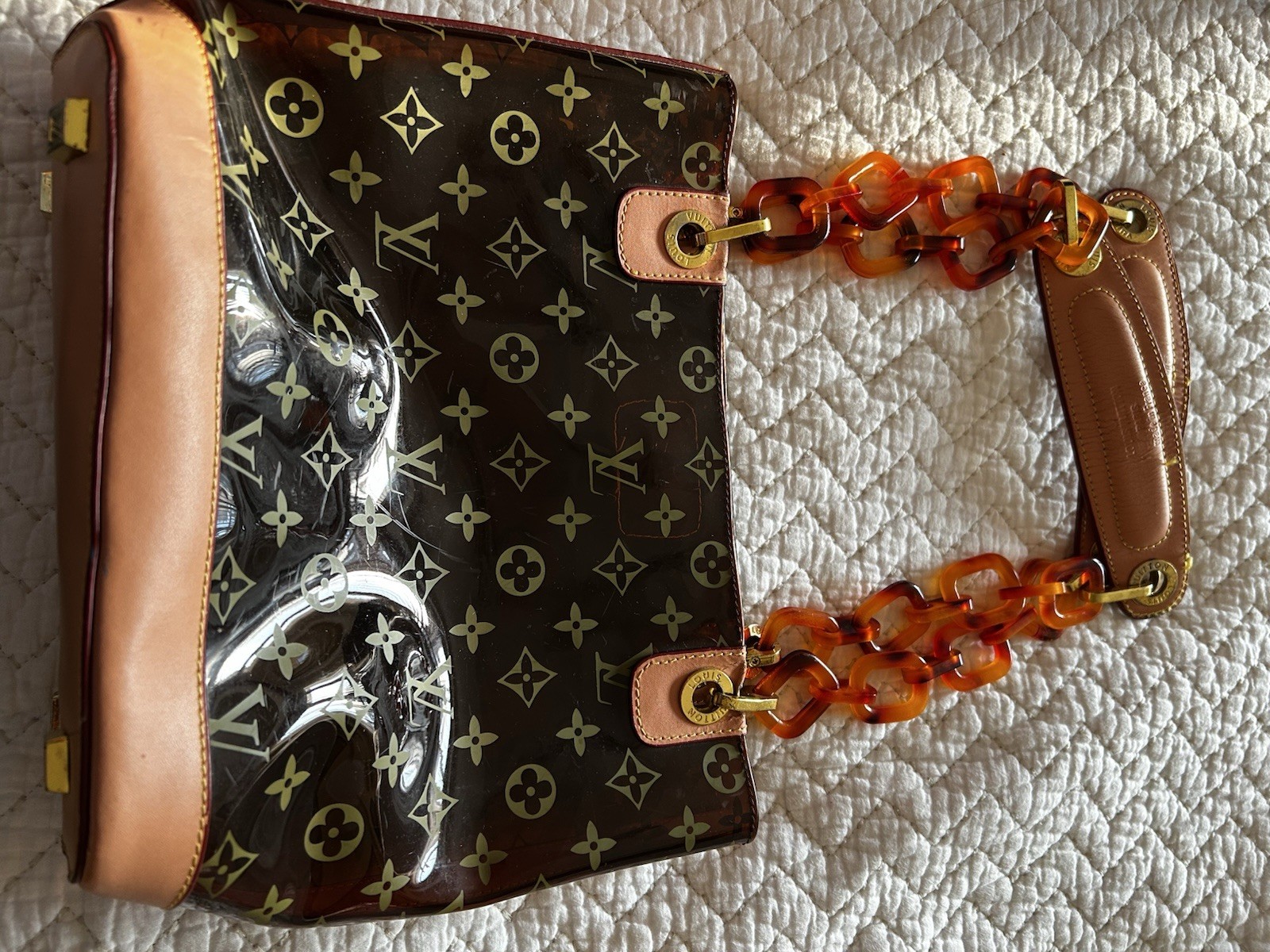 Purse vinyl exterior,amber-colored resin chain straps, and gold-tone hardware
