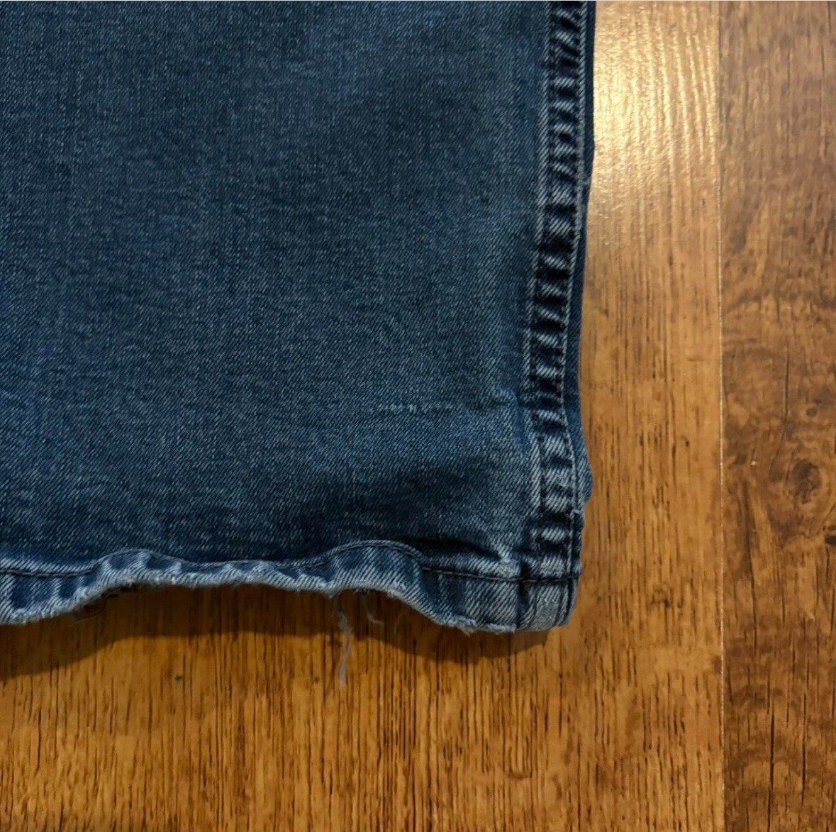 faded Levi’s 514 blue jeans size 38×30 with distressed areas, straight-leg