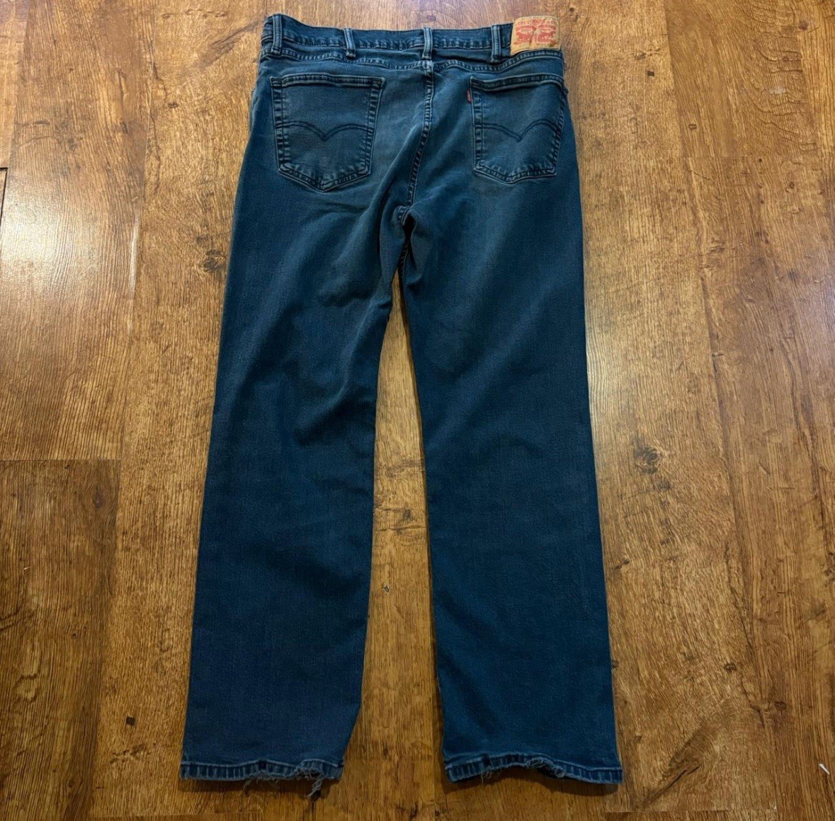 faded Levi’s 514 blue jeans size 38×30 with distressed areas, straight-leg