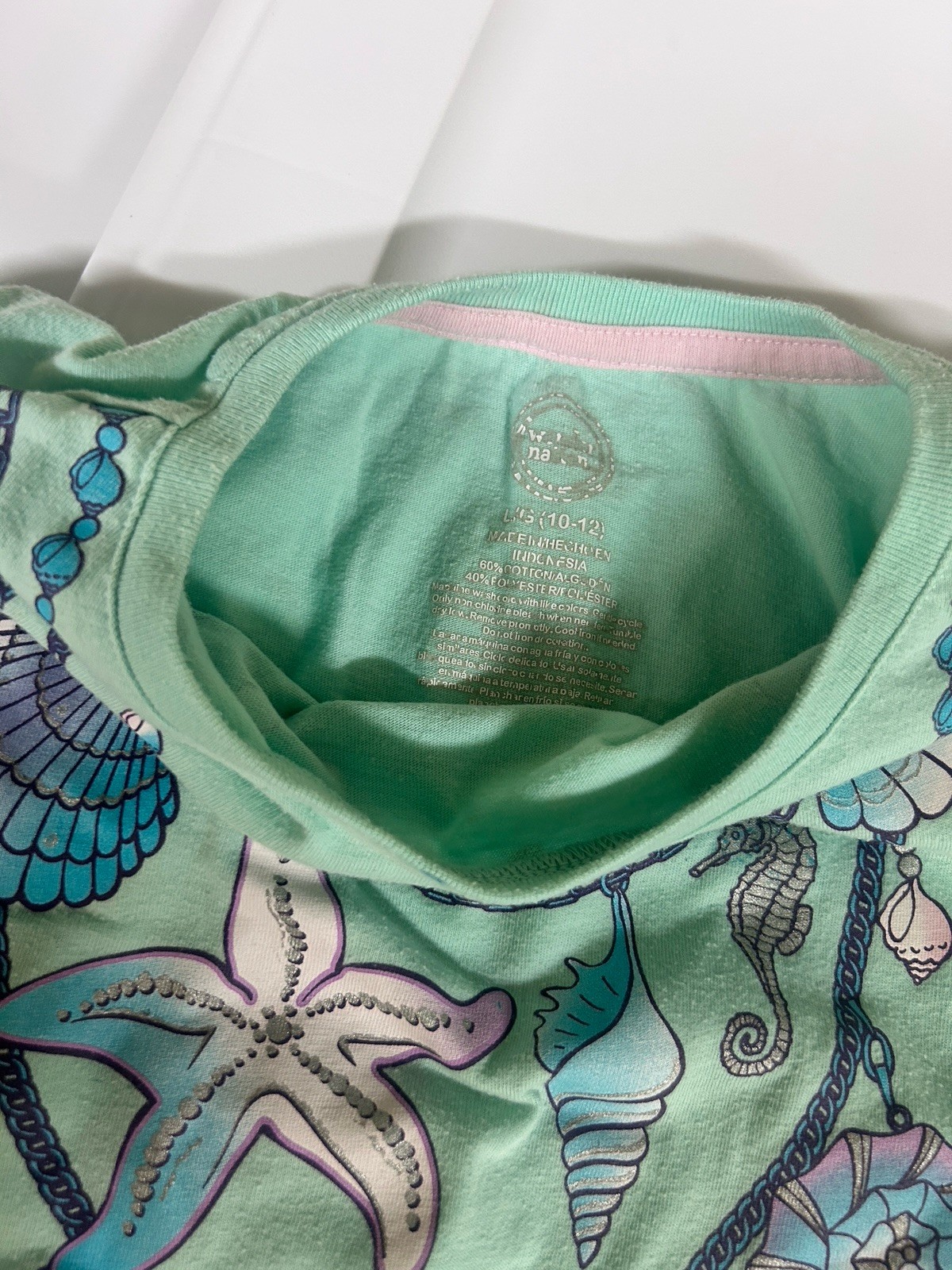 mint green tee with a seaside shell and starfish necklace graphic. Girls L 10-12