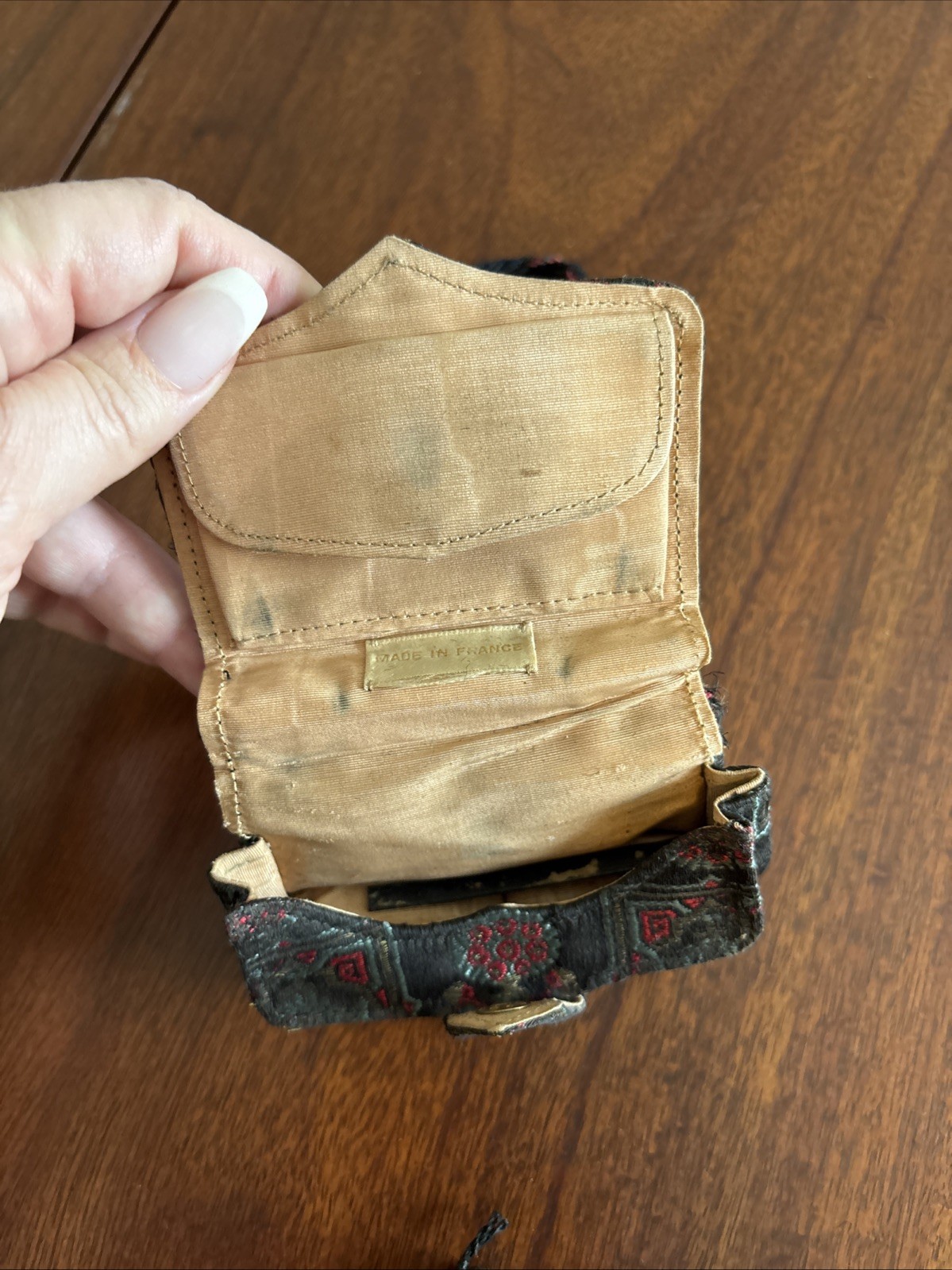 vintage, small tapestry purse with a dark woven pattern and a braided strap.