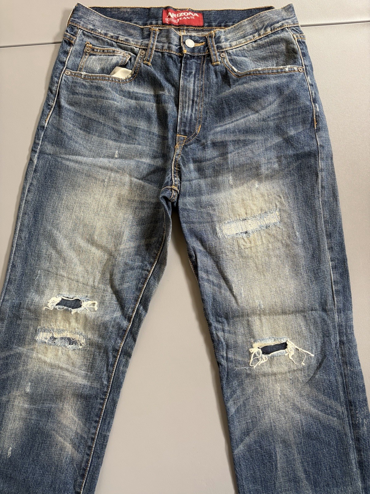 Arizona Jean Co. blue jeans featuring a distressed, light-wash denim style Mens