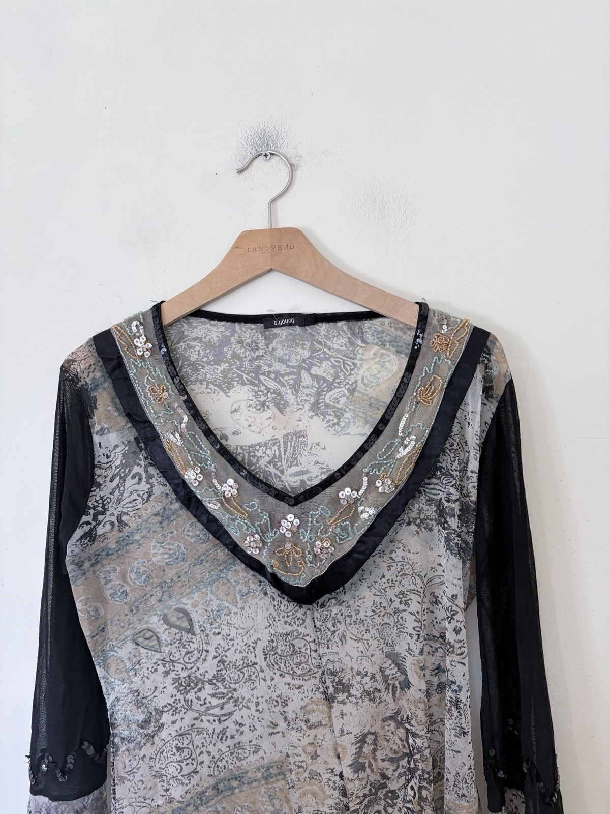Vintage long sleeve top features a grey and black paisley print with intricate b