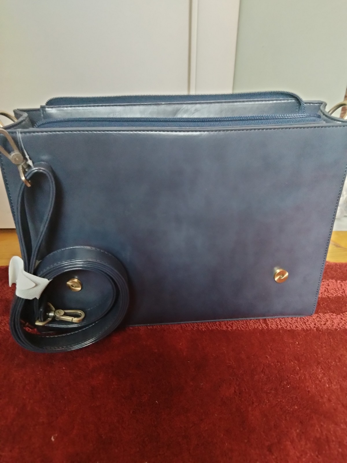 ECOSUSI briefcase features vegan leather construction and a protective handle…