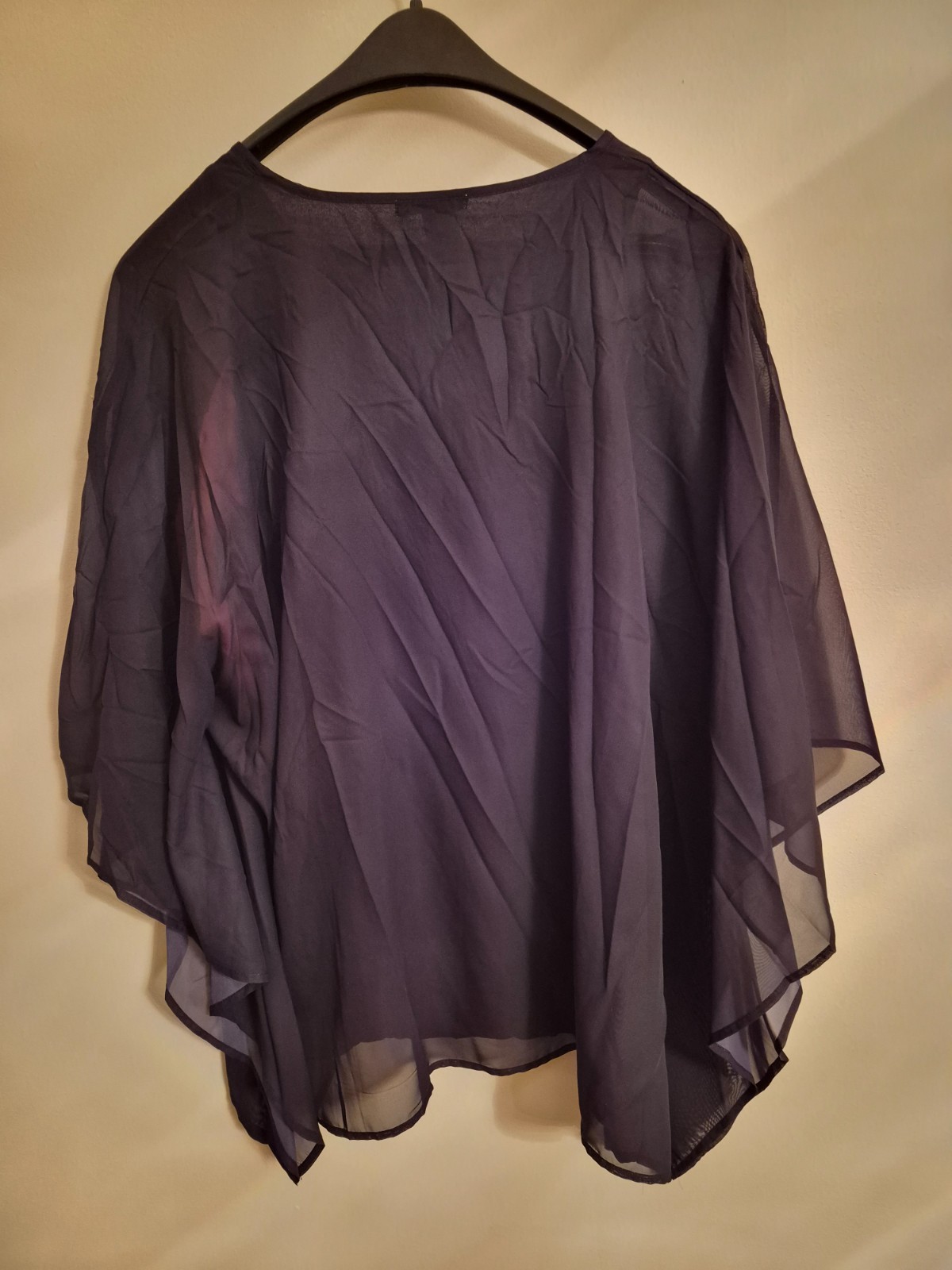 Sheer black poncho style top with tank top lining. Red floral design.