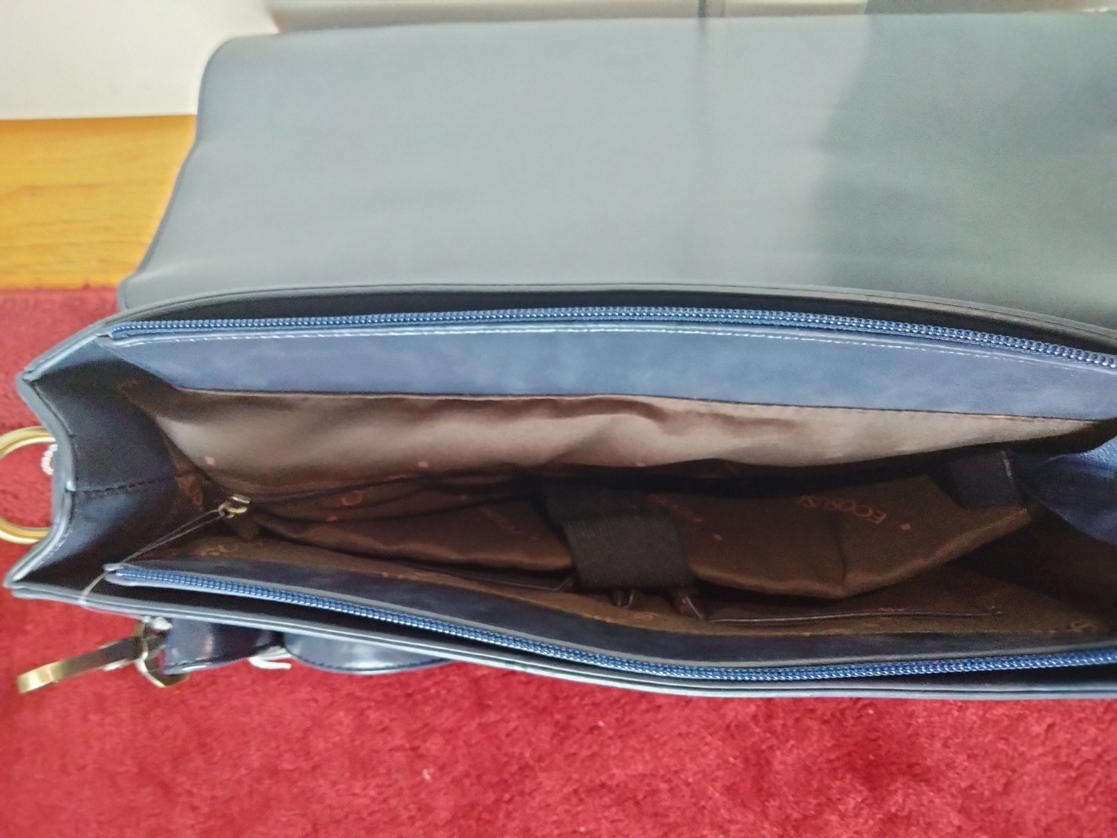 ECOSUSI briefcase features vegan leather construction and a protective handle…