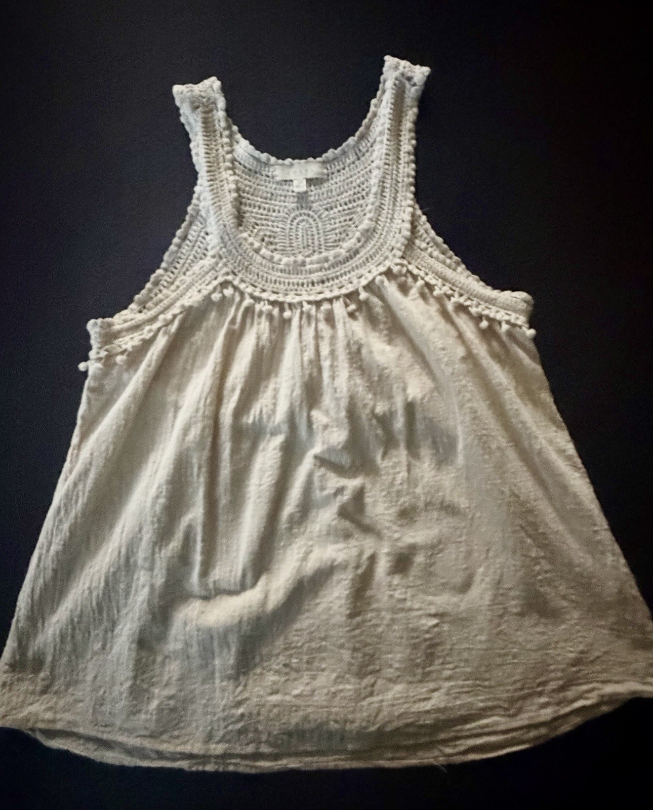 Adiva cream sleeveless top featuring a distinctive crochet yoke and pom-pom trim