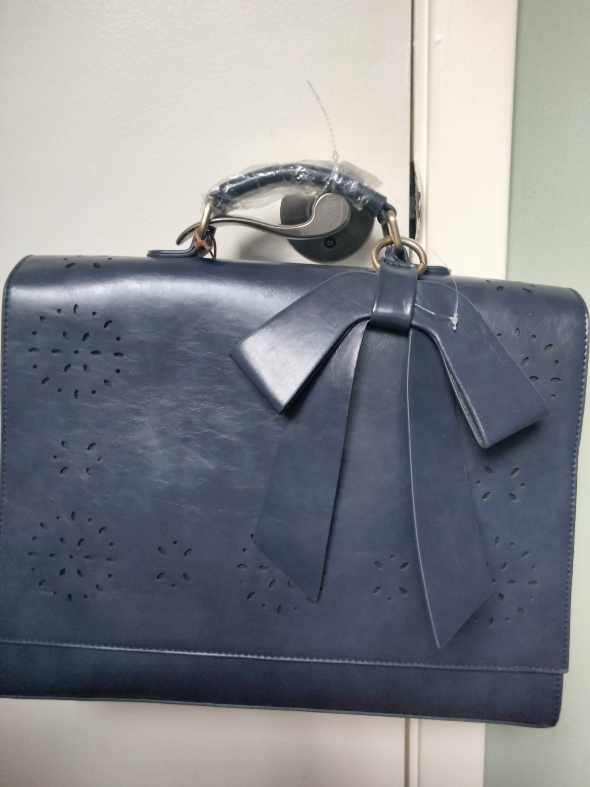 ECOSUSI briefcase features vegan leather construction and a protective handle…