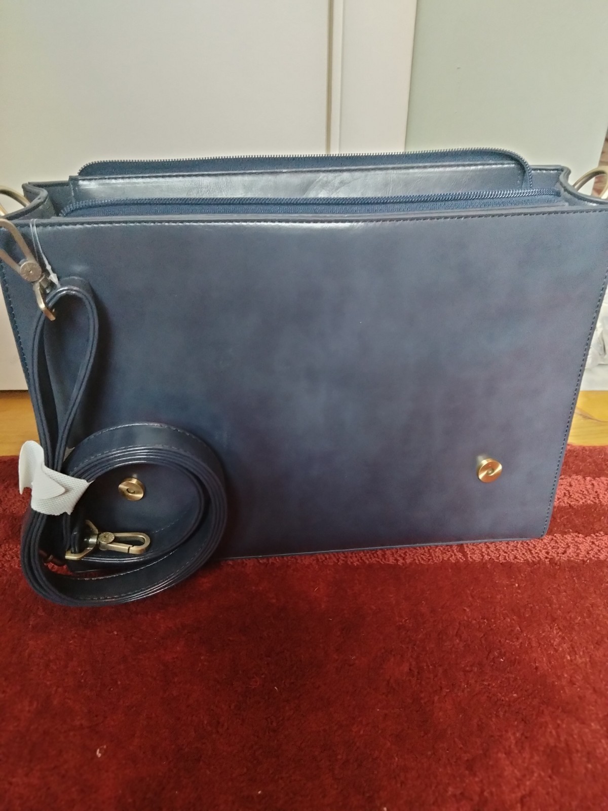 ECOSUSI briefcase features vegan leather construction and a protective handle…