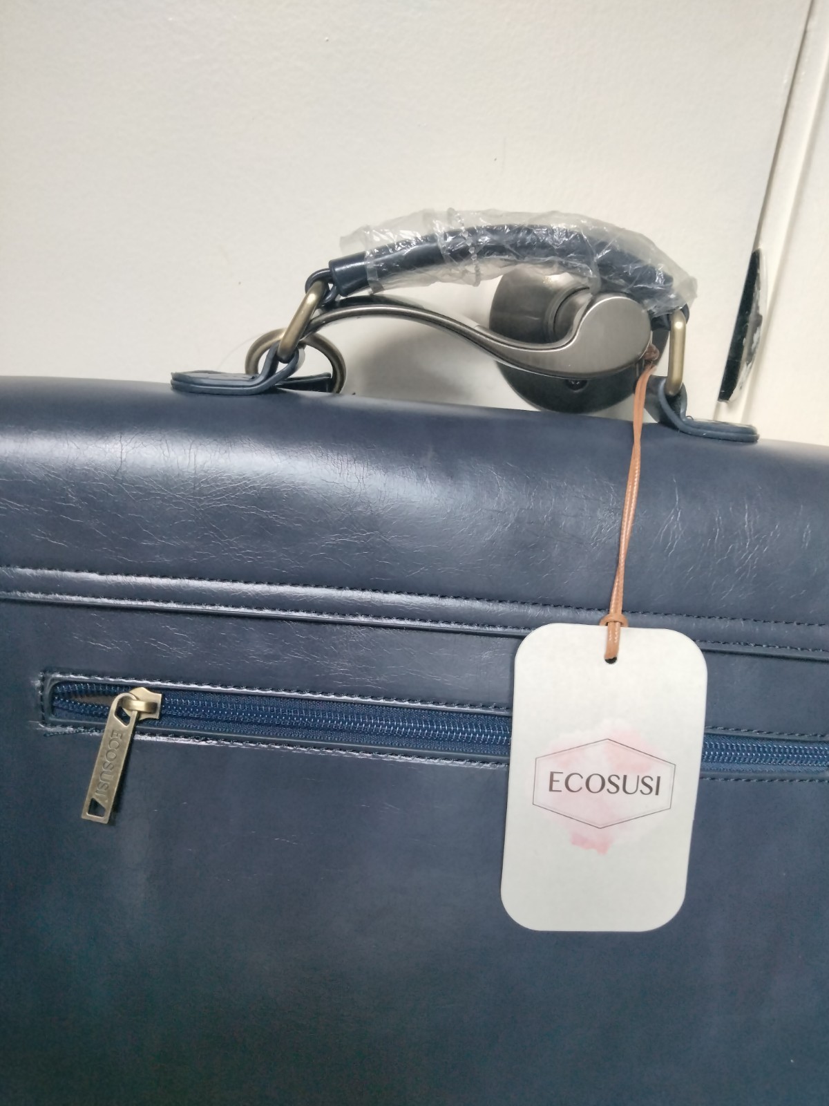 ECOSUSI briefcase features vegan leather construction and a protective handle…