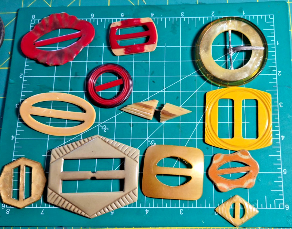 12 Vintage antique celluloid buckles or slides reds yellow art deco shapes
