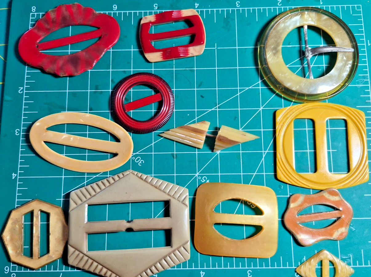 12 Vintage antique celluloid buckles or slides reds yellow art deco shapes