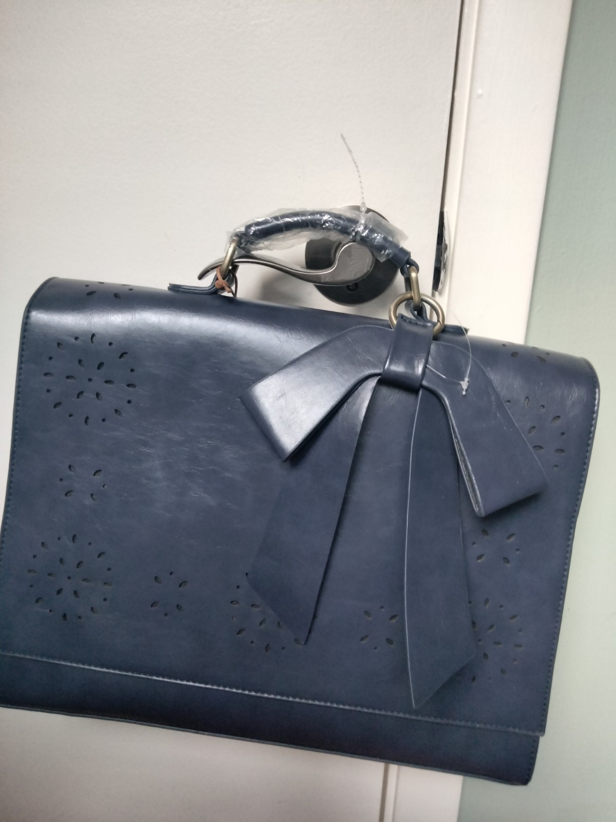 ECOSUSI briefcase features vegan leather construction and a protective handle…