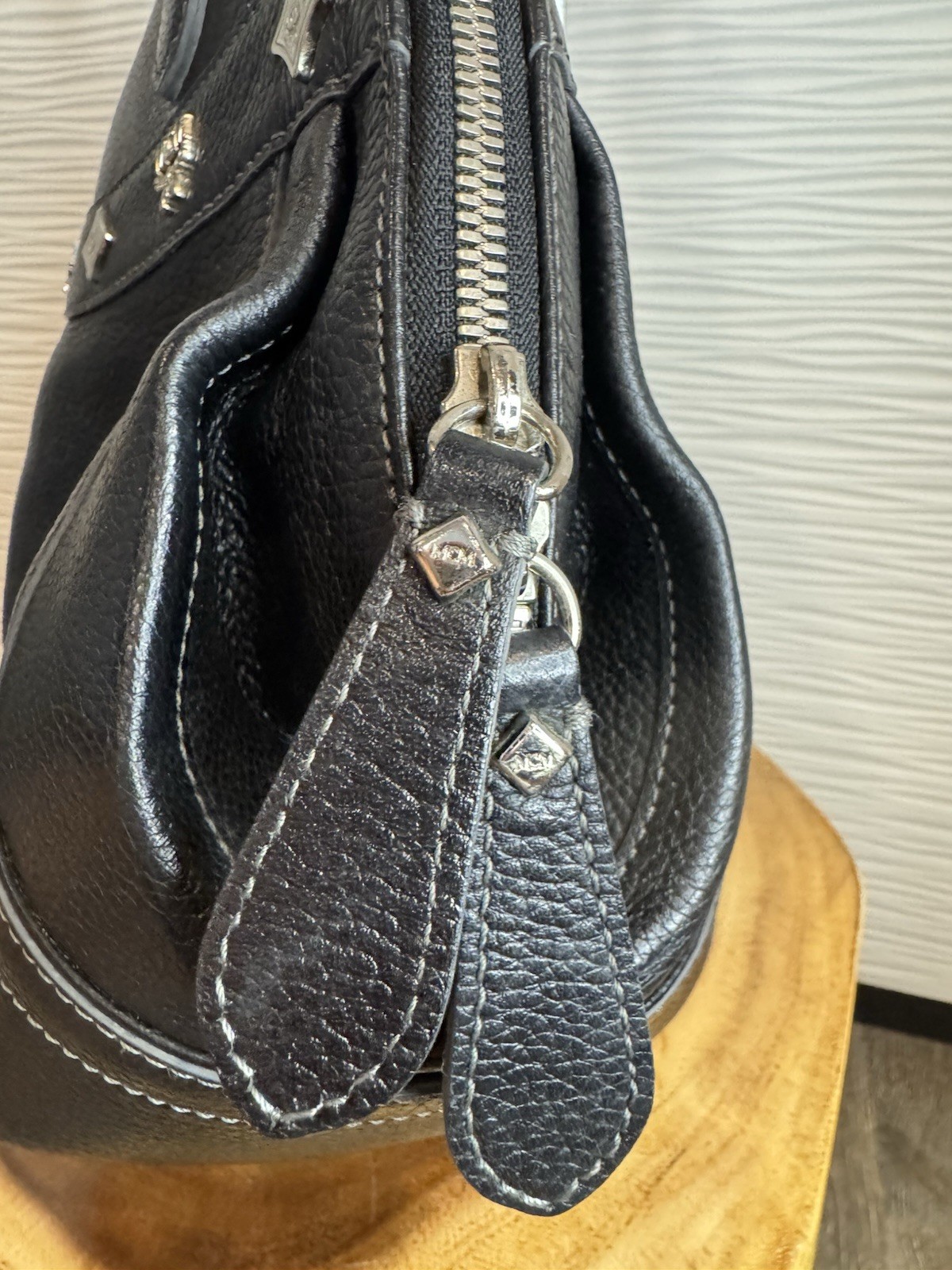 Black MCM Alda satchel with studded logo accents and structured handles.