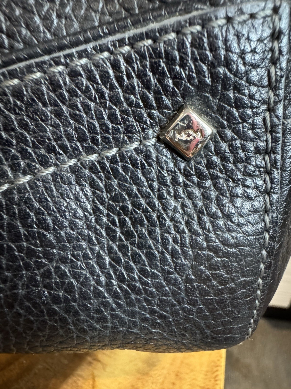 Black MCM Alda satchel with studded logo accents and structured handles.